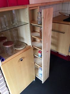 an open cabinet in the middle of a kitchen