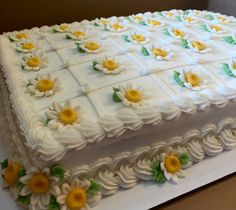 a cake with white frosting and yellow flowers on it