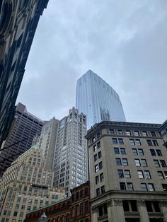 some very tall buildings in the middle of a big city with sky scrapers above them