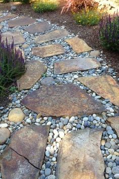 a stone path in the middle of a garden