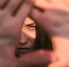 a woman looking through her fingers at the camera