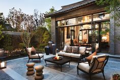 an outdoor living area with furniture and lighting