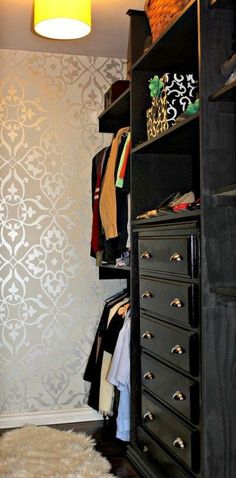 a closet with black drawers and white wallpaper