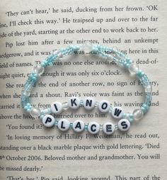 a bracelet with words that spell out know and place on top of an open book