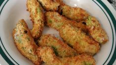 some fried food on a white plate with green trimmings and a fork in the bowl