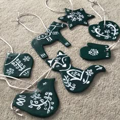 christmas ornaments are hanging on the carpet with white designs and snowflakes around them