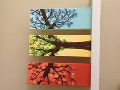 three painted trees on canvases mounted to the wall