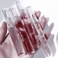 four tubes filled with liquid in the palm of someone's hand