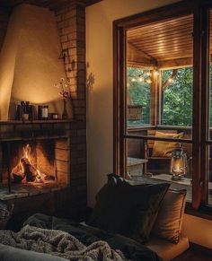 a living room filled with furniture and a fire place in front of a large window