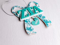 a blue and white keychain with the word zara hanging from it's side