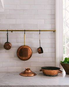 pots and pans are hanging on the wall