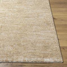 an area rug on the floor with wooden floors and hard wood planks in the background