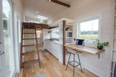 there is a ladder leading up to the loft in this tiny house with wood flooring