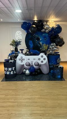 a video game controller surrounded by balloons and other decorations in an office setting with hard wood flooring