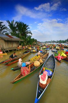 many people are in boats on the water with coconuts and other things around them