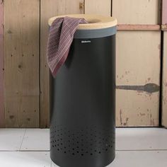 a black trash can with a pink towel on top