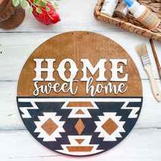 a wooden sign that says home sweet home next to paintbrushes and other items