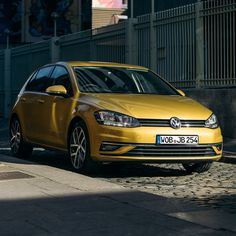 a yellow car is parked on the side of the road