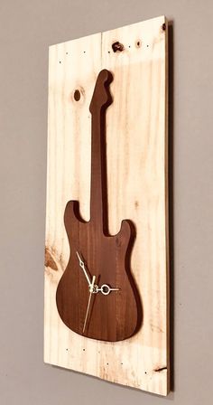 a clock made out of wood with a guitar on it's face and hands