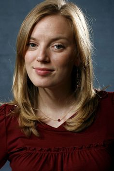 a woman in a red top posing for a photo