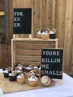 some cupcakes are sitting on a table with small black and white signs that say you're killin'me smalls