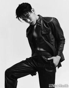 a male in a black leather jacket and pants posing for a magazine cover shot with his hand on his hip