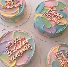 four decorated birthday cakes sitting on top of each other with happy birthday written on them