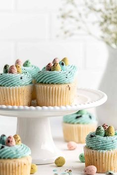 cupcakes with blue frosting and sprinkles on a cake plate