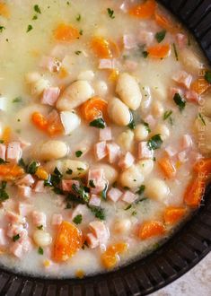 a black bowl filled with soup and vegetables