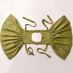 a green bow tie is attached to the back of a dress