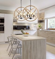 a modern kitchen with an island and chandelier