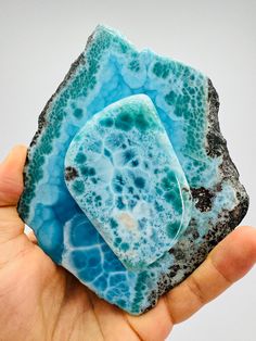 two pieces of blue and black rock in someone's hand