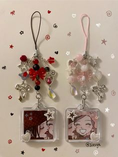 two key chains with charms attached to them on a white surface and stars in the background