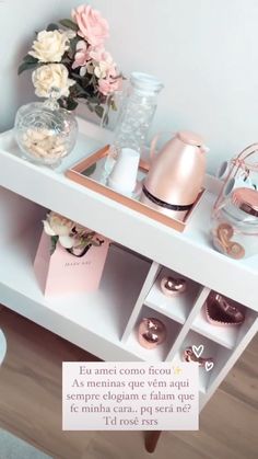 a white table topped with lots of vases filled with flowers next to a wall