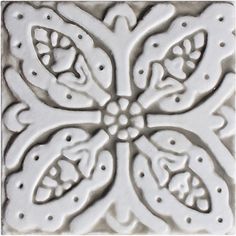 a white tile with an intricate design on it