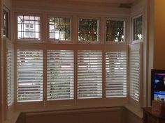 a window with white shutters in a room