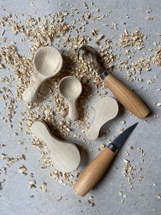 three wooden spoons and some oats on a table