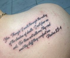 the back of a woman's shoulder with a bible verse on it