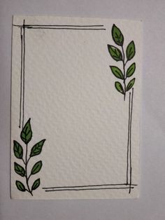 a piece of paper with green leaves on it and a square frame in the middle