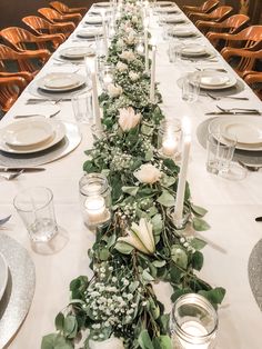 a long table is set with candles and flowers for a formal dinner or wedding reception