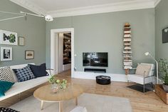 a living room filled with furniture and a flat screen tv sitting on top of a wooden table