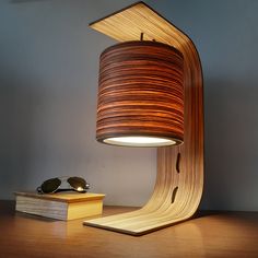 a lamp that is sitting on top of a wooden table next to a pair of glasses