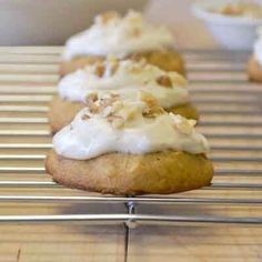 several cookies with white frosting on a cooling rack