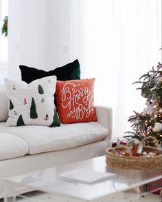 a white couch sitting next to a christmas tree