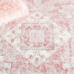 an area rug with pink and white designs on the carpet, including a fur ball