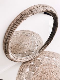 two round rugs sitting next to each other on top of a white floor under a mirror