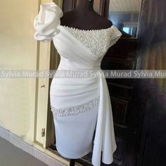 a white dress is on display in front of a mirror