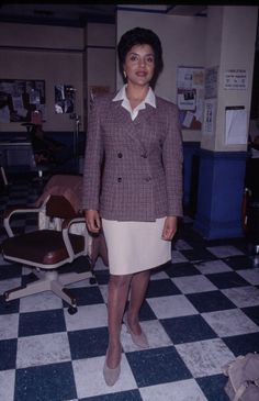 a woman standing in front of a checkered floor