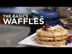 a stack of waffles topped with berries and syrup