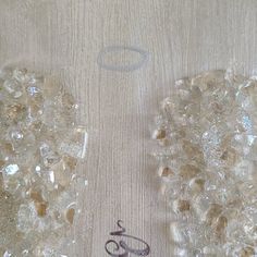 an angel wings with the word love written in arabic on it, surrounded by crystal stones